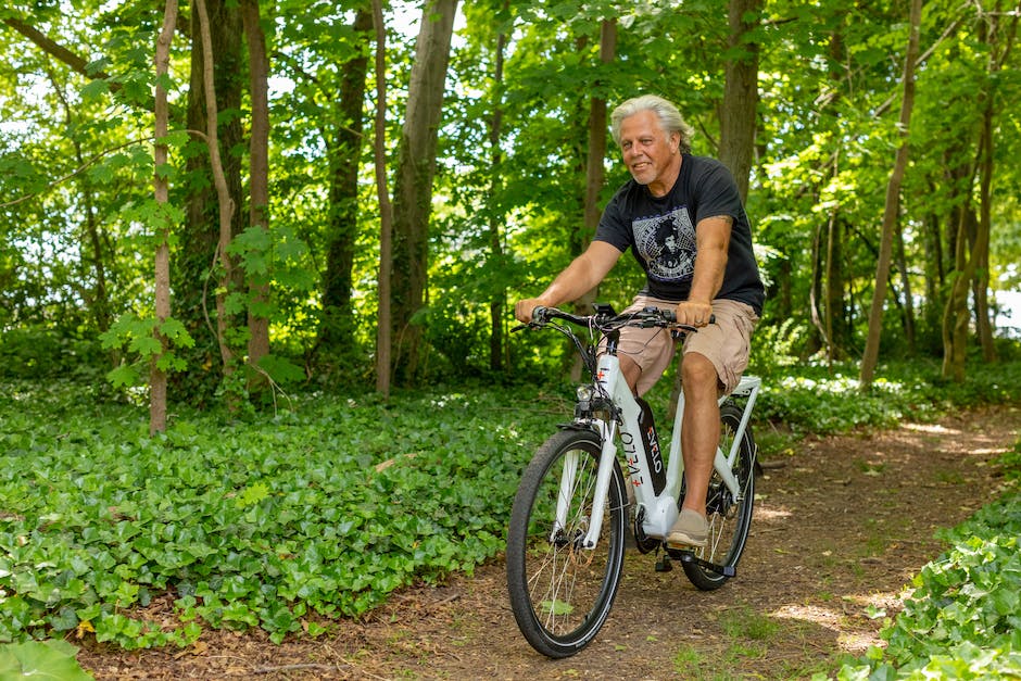 An image of a senior riding an electric bike in a park